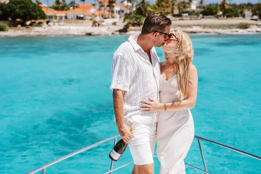 Couple toasting with champagne on the bow of an Eden Luca yacht in Aruba
