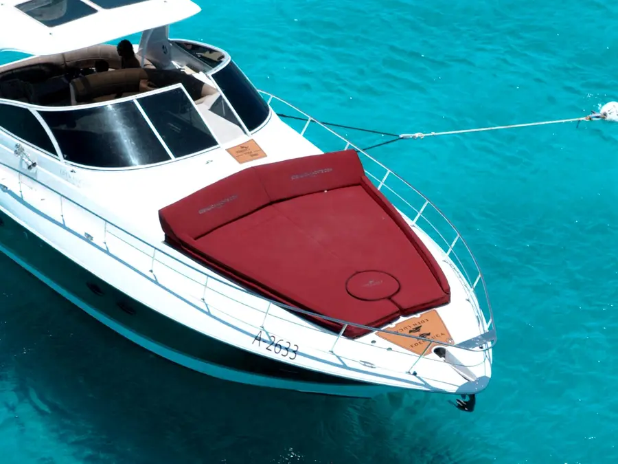 The bordeaux bow sun lounge of Eden Luca Red from above, one continuous cushion over the turquoise sea