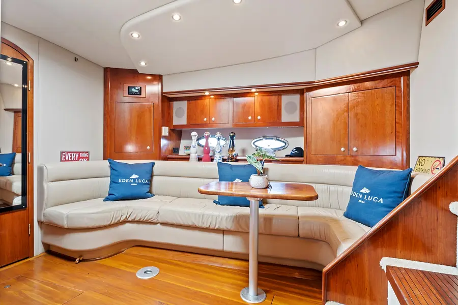 Air-conditioned cabin lounge below deck on Eden Luca Red, cream seating and warm wood