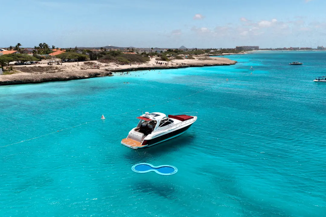 Drone view of Eden Luca Red at anchor in vivid turquoise water off Aruba's coastline